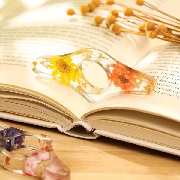 two handmade transparent thumb rings featuring dried flowers, designed as personalized bookmarks for book lovers and teachers, adding a stylish touch to reading.